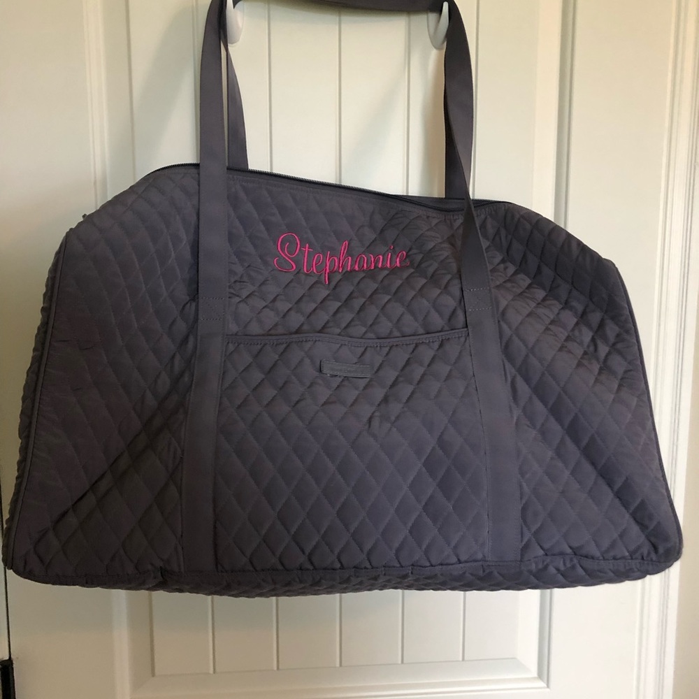 Grey duffel bag embroidered with pink “Stephanie”.